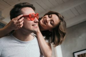couple trying on a pair of cheap novelty sunglasses
